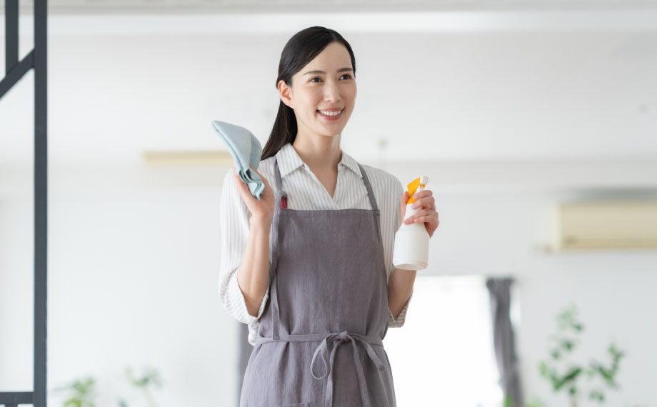 手に掃除用具を持った訪問介護スタッフ
